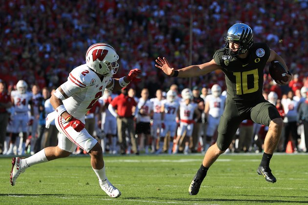 PASADENA, CALIFORNIA - JANUARY 01: Justin Herbert #10 of the Oregon Ducks runs the ball against Reggie Pearson #2 of the Wisconsin Badgers during the first quarter in the Rose Bowl game presented by Northwestern Mutual at Rose Bowl on January 01, 2020 in Pasadena, California. (Photo by Sean M. Haffey/Getty Images)