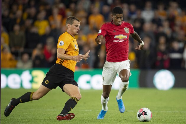 WOLVERHAMPTON, ENGLAND - AUGUST 19: Marcus Rashford of Manchester United is tackled by Ryan Bennett of Wolverhamapton Wanderers during the Premier League match between Wolverhampton Wanderers and Manchester United at Molineux on August 19, 2019 in Wolverhampton, United Kingdom. (Photo by Visionhaus)