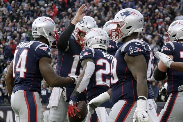 Tom Brady (atrás), quarterback de los Patriots de Nueva Inglaterra, felicita al corredor James White (centro), quien anotó ante los Dolphins de Miami en el partido del domingo 29 de diciembre de 2019 (AP Foto/Elise Amendola)