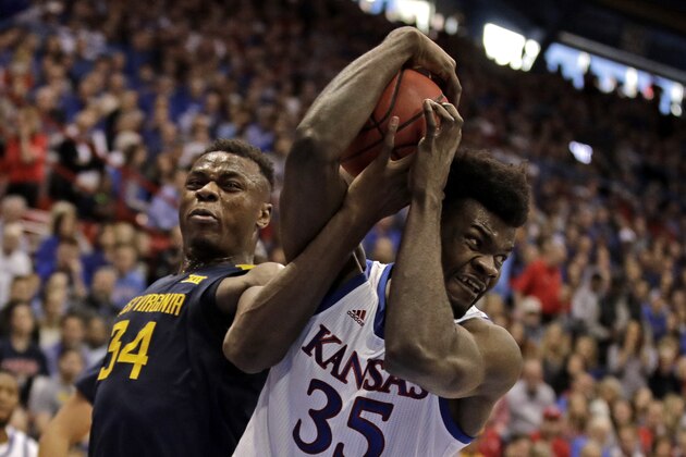 West Virginia's Oscar Tshiebwe (34) steals the ball from Kansas' Udoka Azubuike (35) during the first half of an NCAA college basketball game Saturday, Jan. 4, 2020, in Lawrence, Kan. (AP Photo/Charlie Riedel)