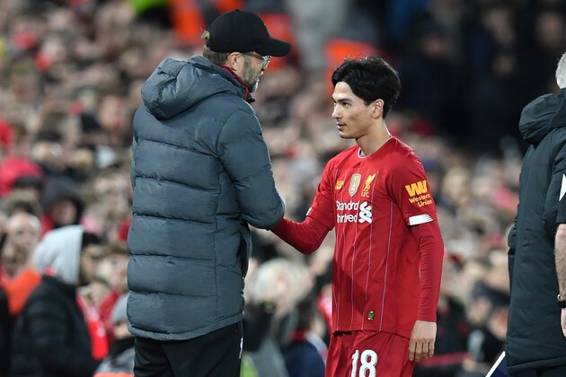 Liverpool's German manager Jurgen Klopp (L) speaks with Liverpool's Japanese midfielder Takumi Minamino (R) as he's substituted during the English FA Cup third round football match between Liverpool and Everton at Anfield in Liverpool, north west England on January 5, 2020. (Photo by Paul ELLIS / AFP) / RESTRICTED TO EDITORIAL USE. No use with unauthorized audio, video, data, fixture lists, club/league logos or 'live' services. Online in-match use limited to 120 images. An additional 40 images may be used in extra time. No video emulation. Social media in-match use limited to 120 images. An additional 40 images may be used in extra time. No use in betting publications, games or single club/league/player publications. /  (Photo by PAUL ELLIS/AFP via Getty Images)