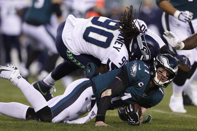 Seattle Seahawks' Jadeveon Clowney (90) hits Philadelphia Eagles' Carson Wentz (11) during the first half of an NFL wild-card playoff football game, Sunday, Jan. 5, 2020, in Philadelphia. (AP Photo/Julio Cortez)