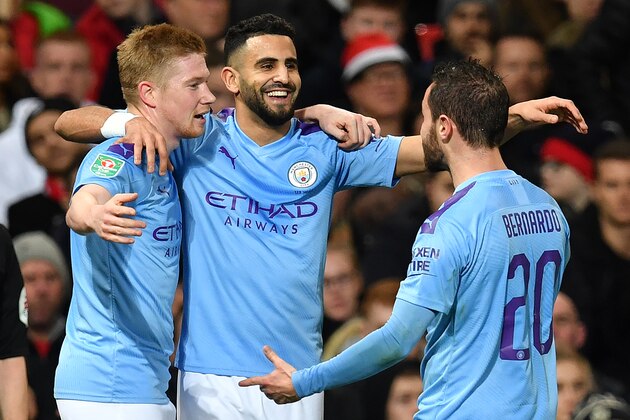 Manchester City's Algerian midfielder Riyad Mahrez (C) celebrates scoring his team's second goal with Manchester City's Belgian midfielder Kevin De Bruyne (L) and Manchester City's Portuguese midfielder Bernardo Silva during the English League Cup semi-final first leg football match between Manchester United and Manchester City at Old Trafford in Manchester, north west England on January 7, 2020. (Photo by Paul ELLIS / AFP) / RESTRICTED TO EDITORIAL USE. No use with unauthorized audio, video, data, fixture lists, club/league logos or 'live' services. Online in-match use limited to 75 images, no video emulation. No use in betting, games or single club/league/player publications. /  (Photo by PAUL ELLIS/AFP via Getty Images)