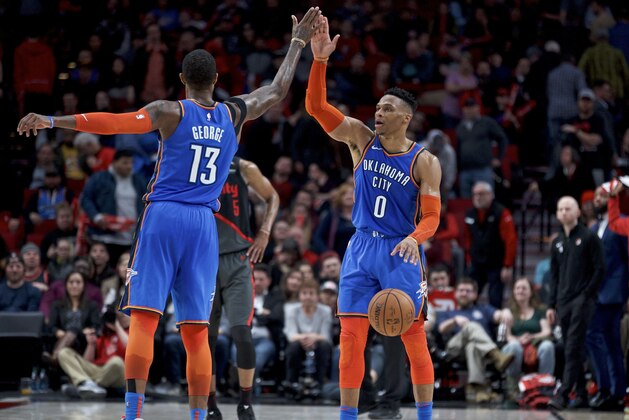Oklahoma City Thunder guard Russell Westbrook, right, and forward Paul George high-five at the end of overtime of an NBA basketball game against the Portland Trail Blazers in Portland, Ore., Thursday, March 7, 2019. The Thunder won 129-121. (AP Photo/Craig Mitchelldyer)