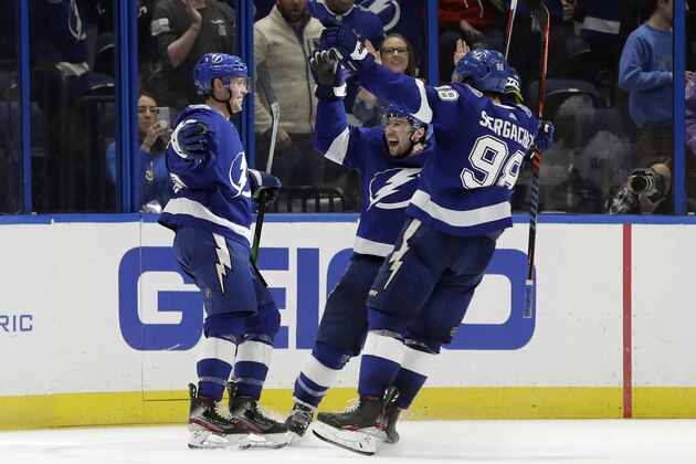 Tampa Bay Lightning center Carter Verhaeghe, left, celebrates his goal against the Vancouver Canucks with Tampa Bay Lightning center Tyler Johnson, center, and defenseman Mikhail Sergachev, right, during the third period of an NHL hockey game Tuesday, Jan. 7, 2020, in Tampa, Fla. (AP Photo/Chris O'Meara)