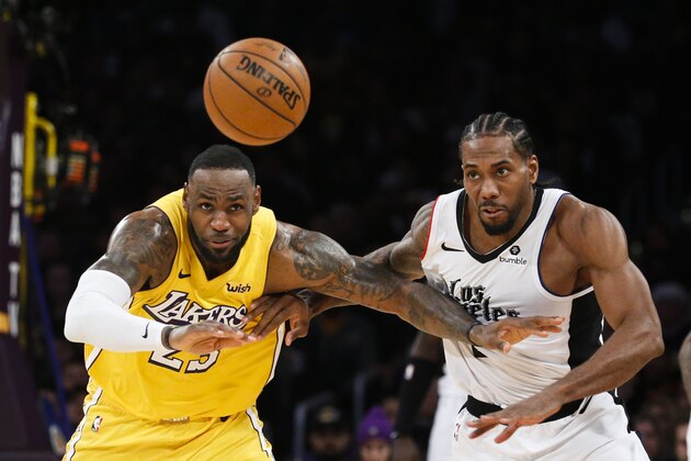 Los Angeles Lakers' LeBron James (23) and Los Angeles Clippers' Kawhi Leonard (2) chase the ball during an NBA basketball game between Los Angeles Lakers and Los Angeles Clippers, Wednesday, Dec. 25, 2019, in Los Angeles. The Clippers won 111-106. (AP Photo/Ringo H.W. Chiu)
