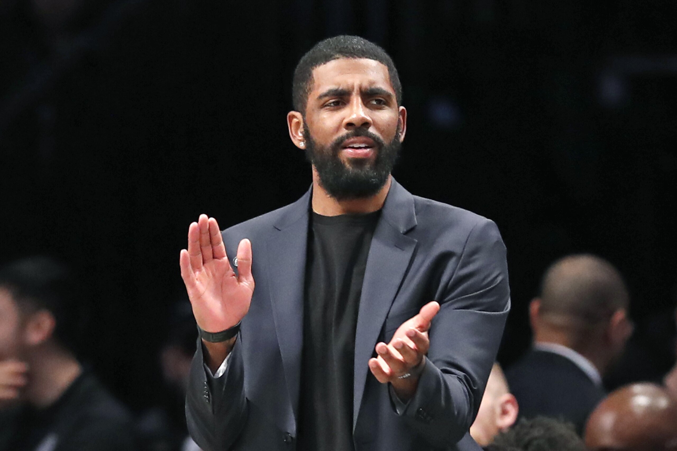 Injured Brooklyn Nets guard Kyrie Irving applauds his teammates from the bench during the first half of an NBA basketball game against the Oklahoma City Thunder, Tuesday, Jan. 7, 2020, in New York. (AP Photo/Kathy Willens)
