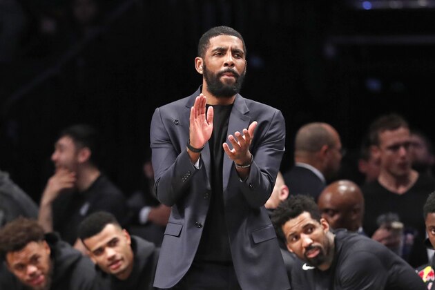 Injured Brooklyn Nets guard Kyrie Irving applauds his teammates from the bench during the first half of an NBA basketball game against the Oklahoma City Thunder, Tuesday, Jan. 7, 2020, in New York. (AP Photo/Kathy Willens)