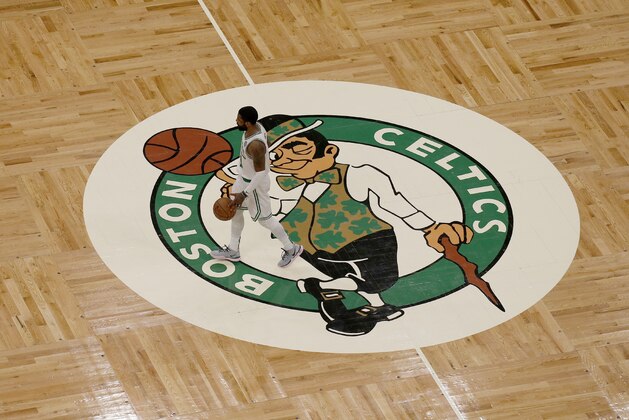 Boston Celtics guard Kyrie Irving (11) dribbles the ball across the Boston Celtics logo at center court on the parquet floor during the second half of an NBA basketball game against the Portland Trail Blazers, Wednesday, Feb. 27, 2019, in Boston. (AP Photo/Mary Schwalm)
