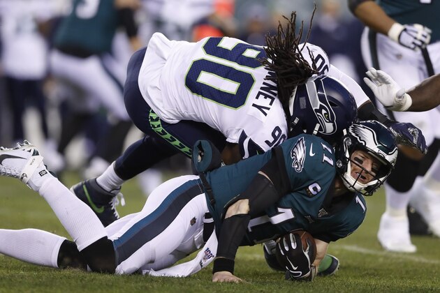 Seattle Seahawks' Jadeveon Clowney (90) hits Philadelphia Eagles' Carson Wentz (11) during the first half of an NFL wild-card playoff football game, Sunday, Jan. 5, 2020, in Philadelphia. Wentz was injured on the play. (AP Photo/Julio Cortez)