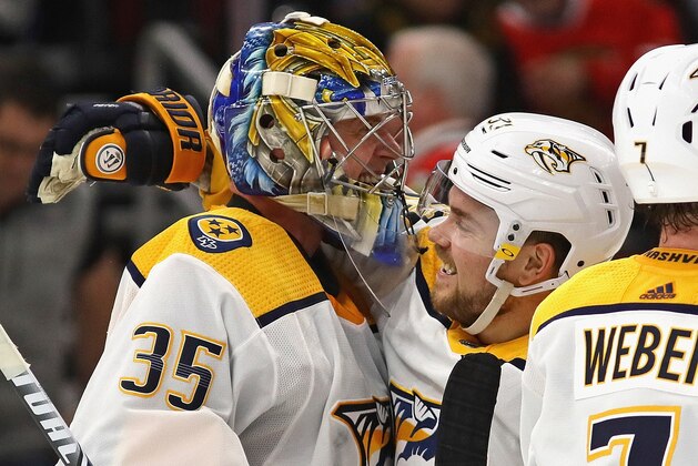 CHICAGO, ILLINOIS - JANUARY 09: Pekka Rinne #35 of the Nashville Predators celebrates a win against the Chicago Blackhawks and his first career goal, an empty net shot, with Viktor Arvidsson #33 at the United Center on January 09, 2020 in Chicago, Illinois. The Predators defeated the Blackhawks 5-2. (Photo by Jonathan Daniel/Getty Images)