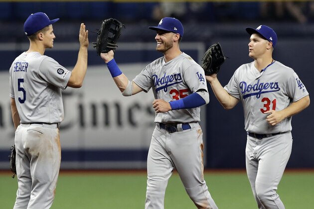 Los Angeles Dodgers shortstop Corey Seager (5) celebrates with first baseman Cody Bellinger (35) and left fielder Joc Pederson (31) after the Dodgers defeated the Tampa Bay Rays during a baseball game Tuesday, May 21, 2019, in St. Petersburg, Fla. (AP Photo/Chris O'Meara)