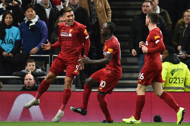 Liverpool's Brazilian midfielder Roberto Firmino (L) celebrates scoring the opening goal during the English Premier League football match between Tottenham Hotspur and Liverpool at Tottenham Hotspur Stadium in London, on January 11, 2020. (Photo by Glyn KIRK / AFP) / RESTRICTED TO EDITORIAL USE. No use with unauthorized audio, video, data, fixture lists, club/league logos or 'live' services. Online in-match use limited to 120 images. An additional 40 images may be used in extra time. No video emulation. Social media in-match use limited to 120 images. An additional 40 images may be used in extra time. No use in betting publications, games or single club/league/player publications. /  (Photo by GLYN KIRK/AFP via Getty Images)
