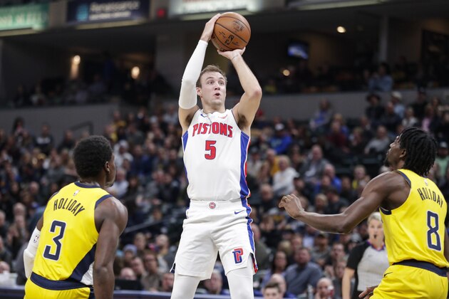 Detroit Pistons guard Luke Kennard (5) shoots over Indiana Pacers guard Aaron Holiday (3) and forward Justin Holiday (8) during the first half of an NBA basketball game in Indianapolis, Friday, Nov. 8, 2019. (AP Photo/Michael Conroy)