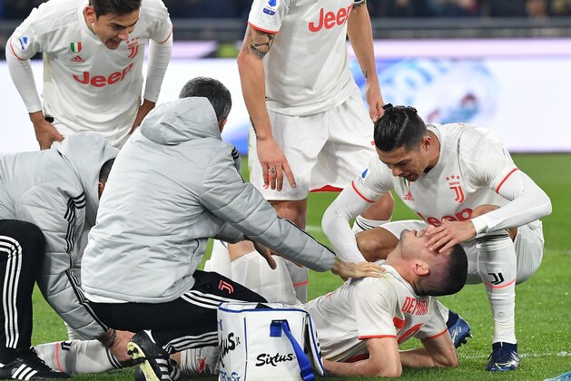 Staff medics (L), Juventus' Argentine forward Paulo Dybala (Top L) and Juventus' Portuguese forward Cristiano Ronaldo (R) tend to Juventus' Turkish defender Merih Demiral after he was injured during the Italian Serie A football match AS Roma vs Juventus on January 12, 2020 at the Olympic stadium in Rome. (Photo by Tiziana FABI / AFP) (Photo by TIZIANA FABI/AFP via Getty Images)