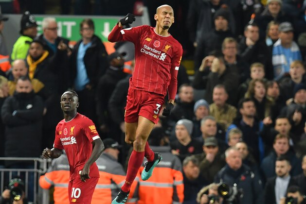 Liverpool's Brazilian midfielder Fabinho (C) jumps in celebrating scoring the opening goal of the English Premier League football match between Liverpool and Manchester City at Anfield in Liverpool, north west England on November 10, 2019. (Photo by Paul ELLIS / AFP) / RESTRICTED TO EDITORIAL USE. No use with unauthorized audio, video, data, fixture lists, club/league logos or 'live' services. Online in-match use limited to 120 images. An additional 40 images may be used in extra time. No video emulation. Social media in-match use limited to 120 images. An additional 40 images may be used in extra time. No use in betting publications, games or single club/league/player publications. /  (Photo by PAUL ELLIS/AFP via Getty Images)