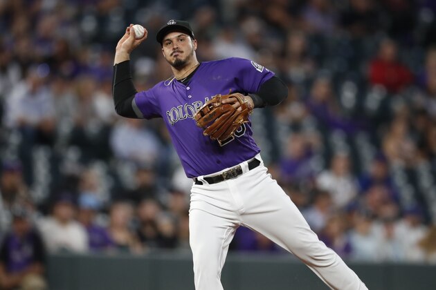 Colorado Rockies third baseman Nolan Arenado throws to first base to put out New York Mets'Todd Frazier during the third inning of a baseball game Tuesday, Sept. 17, 2019, in Denver. (AP Photo/David Zalubowski)