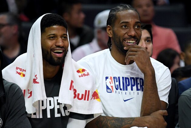 LOS ANGELES, CALIFORNIA - DECEMBER 17:  Paul George #13 and Kawhi Leonard #2 of the LA Clippers laugh on the bench during a 120-99 win over the Phoenix Suns at Staples Center on December 17, 2019 in Los Angeles, California. (Photo by Harry How/Getty Images)