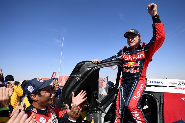 First-placed for the auto category Mini JCW X-RAID Team Spain's driver Carlos Sainz (R), celebrates as he gets out of his car while second-placed Toyota's team Qatar's driver Nasser Al-Attiyah (C) applauds him, on the finish area in Qiddiya at the end of the stage 12 of the Dakar 2020 between Haradh and Qiddiya, Saudi Arabia, on January 17, 2020. (Photo by FRANCK FIFE / AFP) (Photo by FRANCK FIFE/AFP via Getty Images)