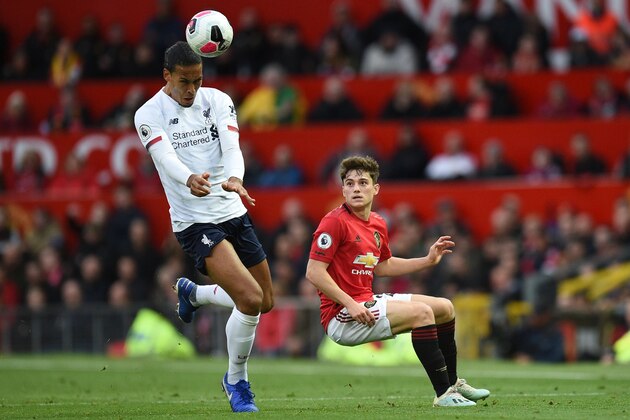 Liverpool's Dutch defender Virgil van Dijk (L) heads the ball as Manchester United's Welsh midfielder Daniel James (R) looks on during the English Premier League football match between Manchester United and Liverpool at Old Trafford in Manchester, north west England, on October 20, 2019. (Photo by Oli SCARFF / AFP) / RESTRICTED TO EDITORIAL USE. No use with unauthorized audio, video, data, fixture lists, club/league logos or 'live' services. Online in-match use limited to 120 images. An additional 40 images may be used in extra time. No video emulation. Social media in-match use limited to 120 images. An additional 40 images may be used in extra time. No use in betting publications, games or single club/league/player publications. /  (Photo by OLI SCARFF/AFP via Getty Images)