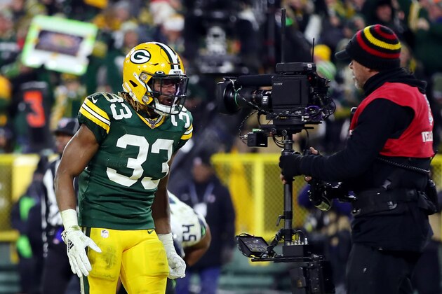 GREEN BAY, WISCONSIN - JANUARY 12: Aaron Jones #33 of the Green Bay Packers celebrates for a TV camera after scoring a touchdown during the second quarter against the Seattle Seahawks in the NFC Divisional Playoff game at Lambeau Field on January 12, 2020 in Green Bay, Wisconsin. (Photo by Gregory Shamus/Getty Images)