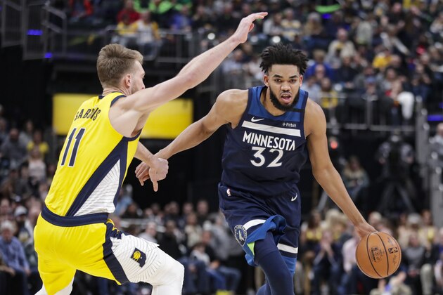 Minnesota Timberwolves center Karl-Anthony Towns (32) drives around Indiana Pacers forward Domantas Sabonis (11) during the first half of an NBA basketball game in Indianapolis, Friday, Jan. 17, 2020. (AP Photo/Michael Conroy)