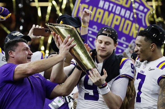 LSU head coach Ed Orgeron, left, and quarterback Joe Burrow, center, hold the trophy beside safety Grant Delpit after a NCAA College Football Playoff national championship game against Clemson, Monday, Jan. 13, 2020, in New Orleans. LSU won 42-25. (AP Photo/Sue Ogrocki)