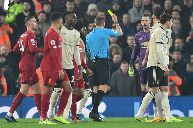 Referee Craig Pawson (C) books Manchester United's Spanish goalkeeper David de Gea (3R) for dissent during the English Premier League football match between Liverpool and Manchester United at Anfield stadium in Liverpool, north west England on January 19, 2020. (Photo by Paul ELLIS / AFP) / RESTRICTED TO EDITORIAL USE. No use with unauthorized audio, video, data, fixture lists, club/league logos or 'live' services. Online in-match use limited to 120 images. An additional 40 images may be used in extra time. No video emulation. Social media in-match use limited to 120 images. An additional 40 images may be used in extra time. No use in betting publications, games or single club/league/player publications. /  (Photo by PAUL ELLIS/AFP via Getty Images)