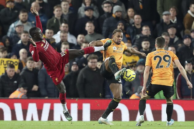 Liverpool's Sadio Mane, left, fights for the ball with Wolverhampton Wanderers' Adama Traore during the English Premier League soccer match between Liverpool and Wolverhampton Wanderers at Anfield Stadium, Liverpool, England, Sunday Dec. 29, 2019. (AP Photo/Jon Super)
