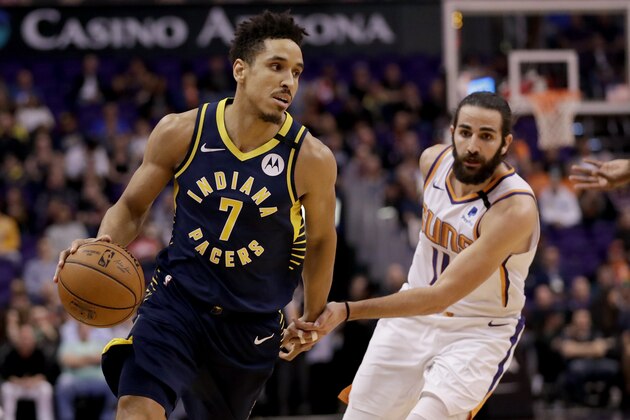 Indiana Pacers guard Malcolm Brogdon (7) drives past Phoenix Suns guard Ricky Rubio (11) during the first half of an NBA basketball game, Wednesday, Jan. 22, 2020, in Phoenix. (AP Photo/Matt York)