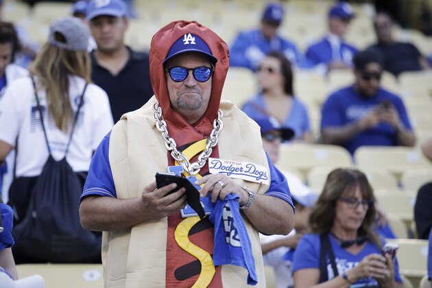 A Los Angeles Dodgers fan watches batting practice before Game 5 of the baseball' team's National League Division Series against the Washington Nationals on Wednesday, Oct. 9, 2019, in Los Angeles. (AP Photo/Marcio Jose Sanchez)