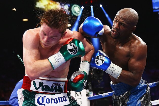 LAS VEGAS, NV - SEPTEMBER 14:  (L-R) Floyd Mayweather Jr. throws a right to Canelo Alvarez during their WBC/WBA 154-pound title fight at the MGM Grand Garden Arena on September 14, 2013 in Las Vegas, Nevada.  (Photo by Al Bello/Getty Images)