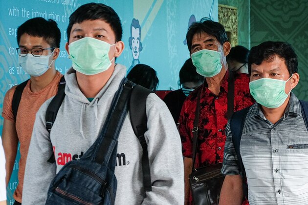 Passengers wearing facemasks to help stop the spread of a deadly virus which began in the Chinese city of Wuhan, arrive at the Sultan Mahmud Badaruddin II International airport in Palembang on January 26, 2020. (Photo by ABDUL QODIR / AFP) (Photo by ABDUL QODIR/AFP via Getty Images)