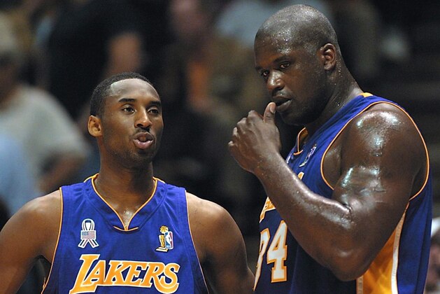 EAST RUTHERFORD, UNITED STATES:  Kobe Bryant (L) and Shaquille O'Neal of the Los Angeles Lakers talk during game four of the NBA Finals against the New Jersey Nets at the Continental Airlines Arena 12 June 2002 in East Rutherford, NJ. The Lakers, led by O'Neal, swept to their third straight National Basketball Association championship with a 113-107 victory over the Nets. AFP PHOTO/Matt CAMPBELL (Photo credit should read MATT CAMPBELL/AFP via Getty Images)