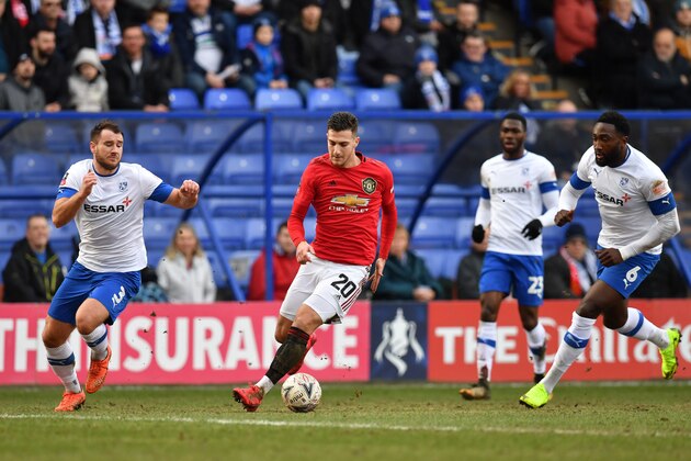 Manchester United's Portuguese defender Diogo Dalot (2nd L) weaves through the Tranmere defence on his way to scoring their second goal during the English FA Cup fourth round football match between Tranmere Rovers and Manchester United at Prenton Park in Birkenhead, north west England, on January 26, 2020. (Photo by Paul ELLIS / AFP) / RESTRICTED TO EDITORIAL USE. No use with unauthorized audio, video, data, fixture lists, club/league logos or 'live' services. Online in-match use limited to 120 images. An additional 40 images may be used in extra time. No video emulation. Social media in-match use limited to 120 images. An additional 40 images may be used in extra time. No use in betting publications, games or single club/league/player publications. /  (Photo by PAUL ELLIS/AFP via Getty Images)