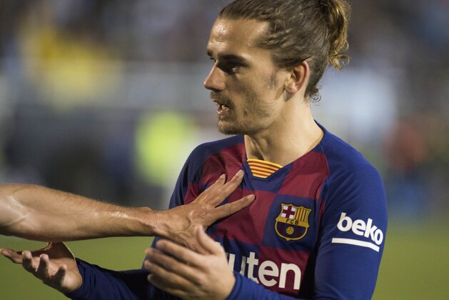 Barcelona's French forward Antoine Griezmann is pushed by an unidentified UD Ibiza's player during the Copa del Rey (King's Cup) football match between UD Ibiza and FC Barcelona at the Can Misses municipal stadium in Ibiza, on January 22, 2020. (Photo by JAIME REINA / AFP) (Photo by JAIME REINA/AFP via Getty Images)