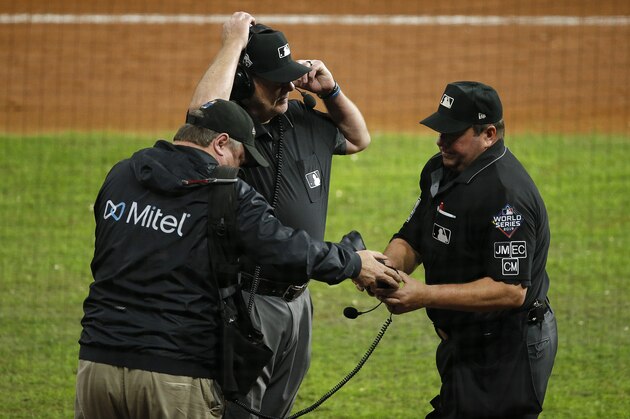 HOUSTON, TEXAS - OCTOBER 29:  Umpires Sam Holbrook #34 and Gary Cederstrom #38 discuss the runner interference call on Trea Turner (not pictured) of the Washington Nationals on headset during the seventh inning in Game Six of the 2019 World Series between the Houston Astros and the Washington Nationals at Minute Maid Park on October 29, 2019 in Houston, Texas. (Photo by Bob Levey/Getty Images)