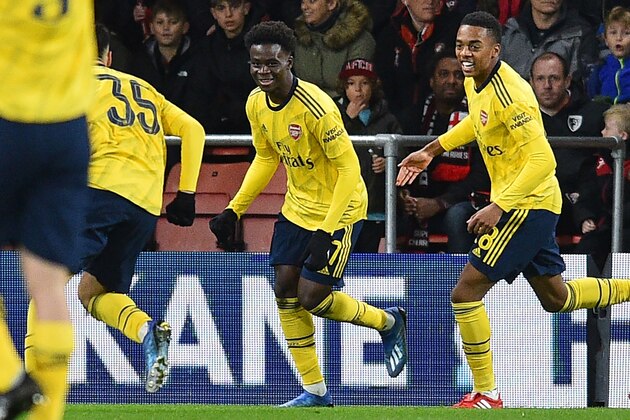 Arsenal's English striker Bukayo Saka (C) celebrates with teammates after scoring the opening goal of the English FA Cup fourth round football match  between Bournemouth and Arsenal at the Vitality Stadium in Bournemouth, southern England on January 27, 2020. (Photo by Glyn KIRK / AFP) / RESTRICTED TO EDITORIAL USE. No use with unauthorized audio, video, data, fixture lists, club/league logos or 'live' services. Online in-match use limited to 120 images. An additional 40 images may be used in extra time. No video emulation. Social media in-match use limited to 120 images. An additional 40 images may be used in extra time. No use in betting publications, games or single club/league/player publications. /  (Photo by GLYN KIRK/AFP via Getty Images)