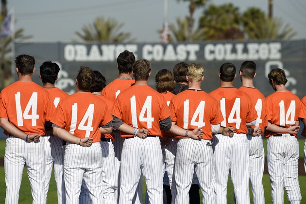 The Orange Coast College baseball players stands for the national anthem while wearing shirts with the number 14 on their backs for late head coach John Altobelli, who died in a helicopter crash alongside former NBA basketball player Kobe Bryant in Costa Mesa, Calif., Tuesday, Jan. 28, 2020. (AP Photo/Kelvin Kuo)
