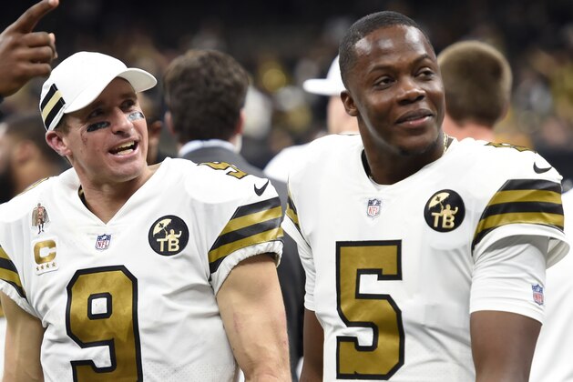 New Orleans Saints quarterback Drew Brees laughs with quarterback Teddy Bridgewater (5) on the sideline in the second half of an NFL football game against the Philadelphia Eagles in New Orleans, Sunday, Nov. 18, 2018. (AP Photo/Bill Feig)