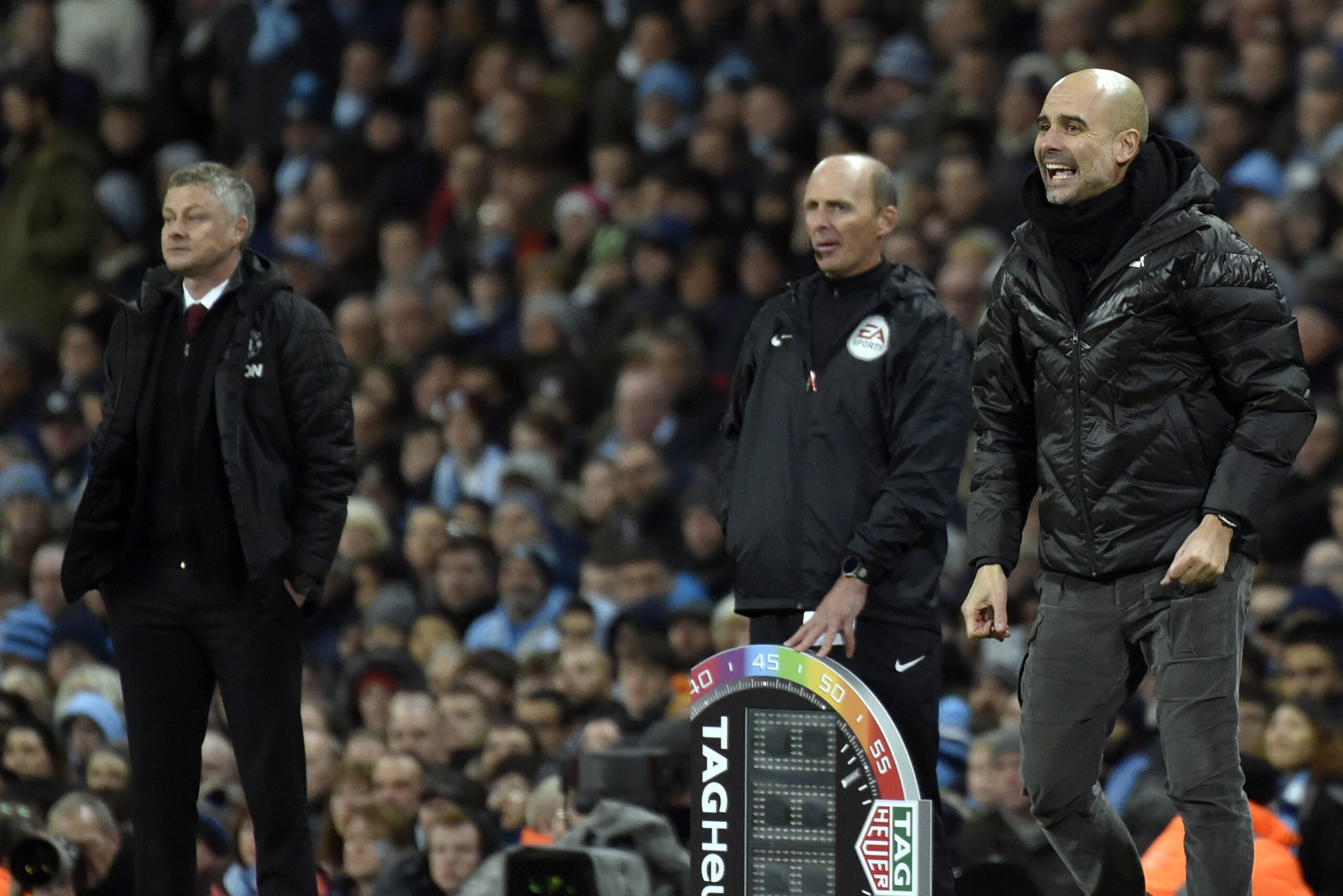 Manchester City's head coach Pep Guardiola, right, and Manchester United's manager Ole Gunnar Solskjaer, left, react during the English Premier League soccer match between Manchester City and Manchester United at Etihad stadium in Manchester, England, Saturday, Dec. 7, 2019. (AP Photo/Rui Vieira)