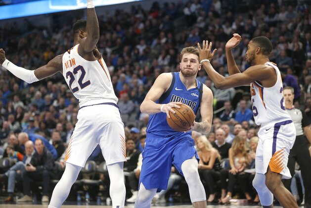 Dallas Mavericks guard Luka Doncic (77) looks to pass as Phoenix Suns center Deandre Ayton (22) and Phoenix Suns forward Mikal Bridges (25) defend during the second half of an NBA basketball game Tuesday, Jan. 28, 2020, in Dallas. Phoenix won 133-104. (AP Photo/Ron Jenkins) Dallas Mavericks guard Luka Doncic (77) looks to pass as Phoenix Suns center Deandre Ayton (22) and Phoenix Suns forward Mikal Bridges (25) defend during the second half of an NBA basketball game Tuesday, Jan. 28, 2020, in Dallas. Phoenix won 133-104. (AP Photo/Ron Jenkins)