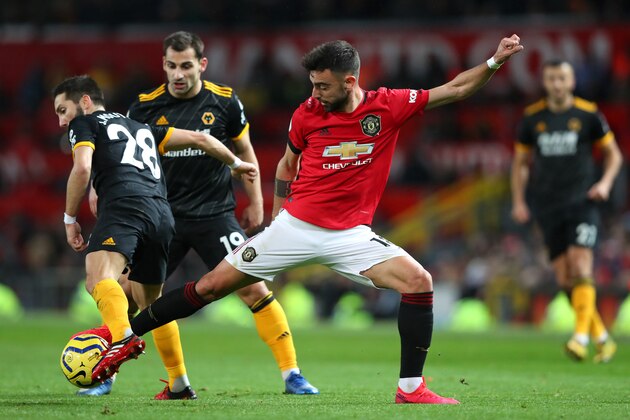 MANCHESTER, ENGLAND - FEBRUARY 01: Joao Moutinho of Wolverhampton Wanderers is challenged by Bruno Fernandes of Manchester United during the Premier League match between Manchester United and Wolverhampton Wanderers at Old Trafford on February 01, 2020 in Manchester, United Kingdom. (Photo by Alex Livesey/Getty Images)