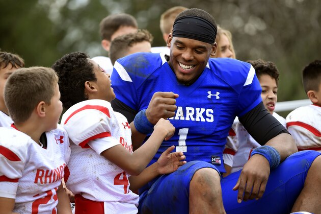 This Jan. 13, 2017 photo shows NFL player Cam Newton, right, bumping fists with youth football player Keilan Matthews, 8, of Santa Clarita, Calif., during the filming of a Buick commercial for this year's Super Bowl telecast in Los Angeles.  The commercial is set to air during the first quarter.  (Photo by Chris Pizzello/Invision/AP)