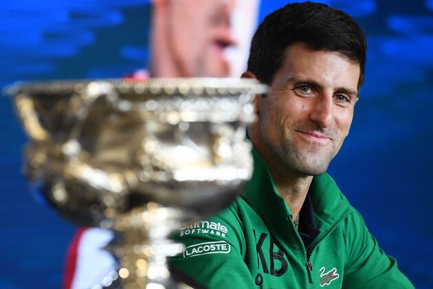 Serbia's Novak Djokovic smiles as he sits beside the Norman Brookes Challenge Cup trophy during a press conference after beating Austria's Dominic Thiem in their men's singles final match on day fourteen of the Australian Open tennis tournament in Melbourne on February 3, 2020. (Photo by John DONEGAN / AFP) / IMAGE RESTRICTED TO EDITORIAL USE - STRICTLY NO COMMERCIAL USE (Photo by JOHN DONEGAN/AFP via Getty Images)
