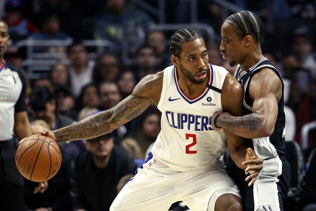 Los Angeles Clippers' Kawhi Leonard (2) is defended by San Antonio Spurs' DeMar DeRozan (10) during the first half of an NBA basketball game, Monday, Feb. 3, 2020, in Los Angeles. (AP Photo/Ringo H.W. Chiu)