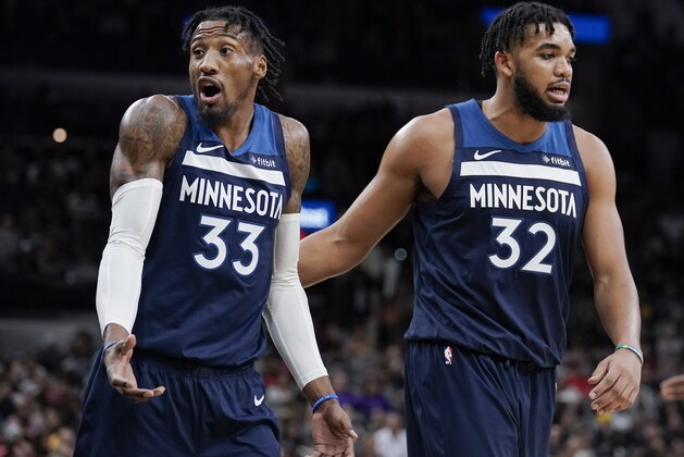 Minnesota Timberwolves' Robert Covington (33) reacts after being called for a technical foul as he walks to the bench with teammate Karl-Anthony Towns in the second half of an NBA basketball game against the San Antonio Spurs, Wednesday, Nov. 27, 2019, in San Antonio. Minnesota won 113-101. (AP Photo/Darren Abate)