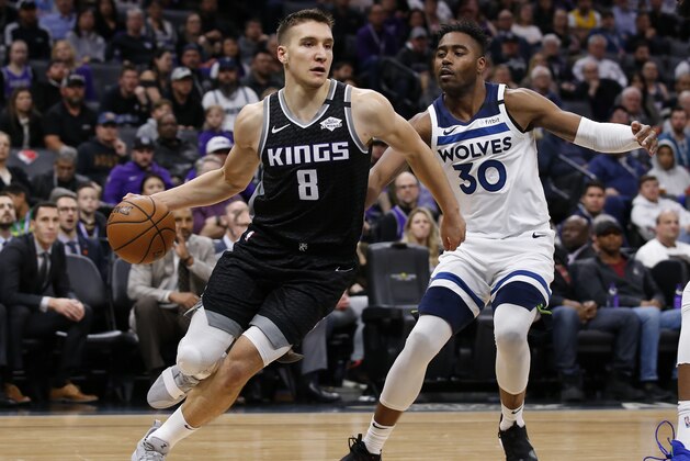 Sacramento Kings guard Bogdan Bogdanovic, left, drives to the basket against Minnesota Timberwolves forward Kelan Martin, right, during the second half of an NBA basketball game in Sacramento, Calif., Monday, Feb. 3, 2020. The Kings won 113-109. (AP Photo/Rich Pedroncelli)