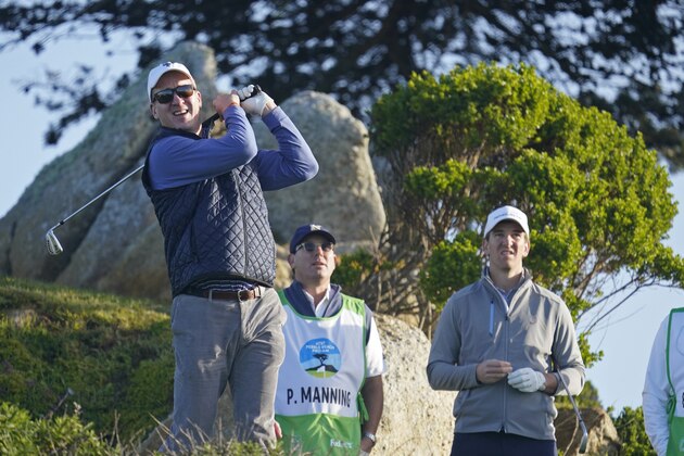 Peyton Manning, left, follows his shot from the 11th tee of the Monterey Peninsula Country Club Shore Course as his brother, Eli Manning, looks on during the second round of the AT&T Pebble Beach National Pro-Am golf tournament Friday, Feb. 7, 2020, in Pebble Beach, Calif. (AP Photo/Tony Avelar)