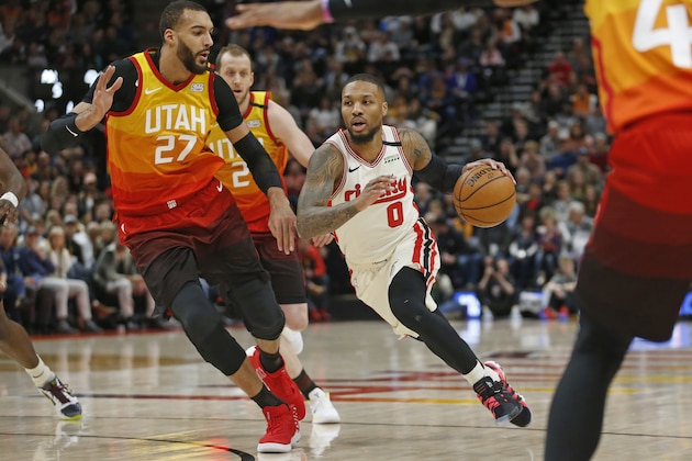 Portland Trail Blazers guard Damian Lillard (0) drives around Utah Jazz center Rudy Gobert (27) during the first half during an NBA basketball game Friday, Feb. 7, 2020, in Salt Lake City. (AP Photo/Rick Bowmer)